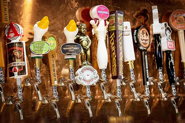 Fileira de torneiras de chope com puxadores de marcas artesanais, incluindo Goose Island, Sierra Nevada e Timmermans
