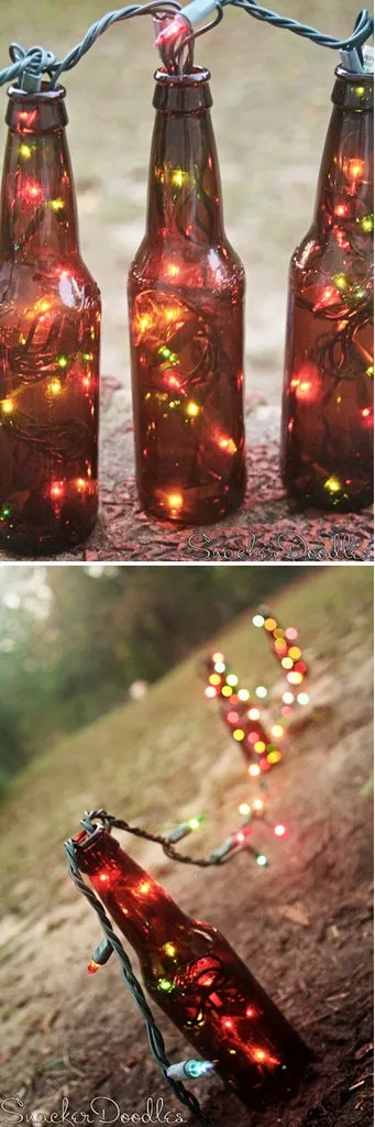 Garrafas de cerveja marrons com pisca-pisca de luzes coloridas dentro, sobre pedra e na grama