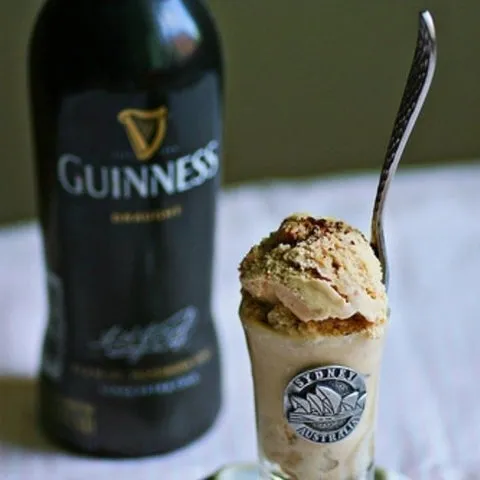 Sorvete de creme com Guinness em copinho com colher, ao lado de uma garrafa de Guinness