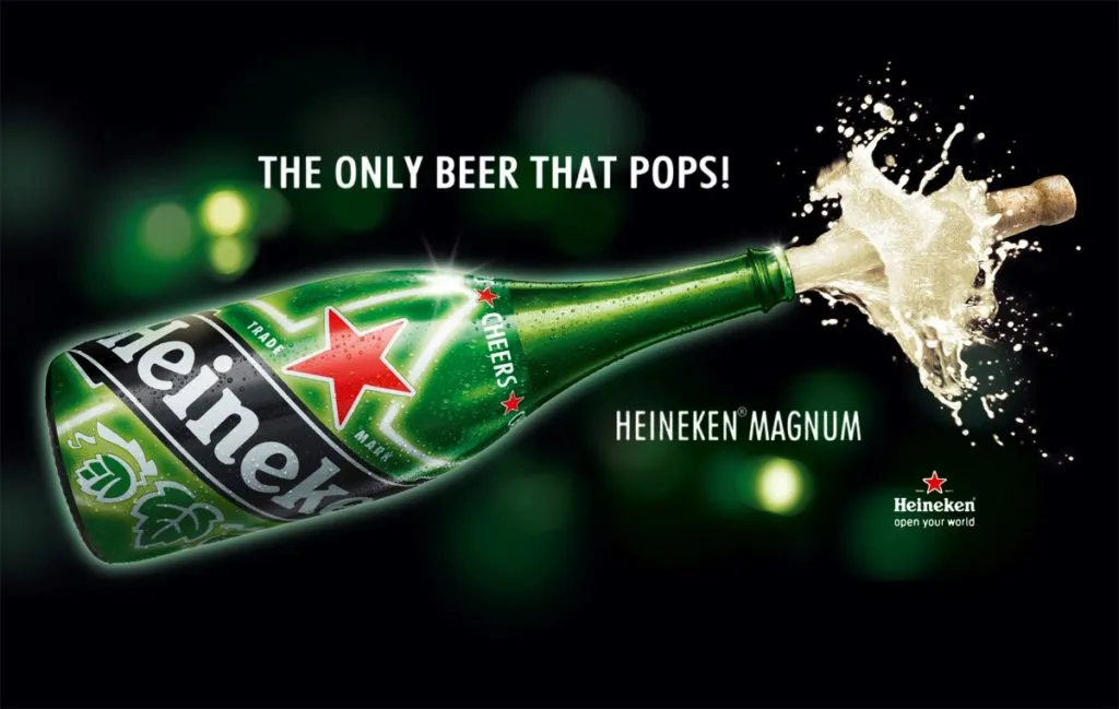 Anúncio da Heineken Magnum com garrafa gigante estourando e espuma jorrando da rolha, e o texto The only beer that pops