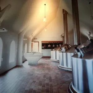 Sala da cervejaria com cubas de aço inoxidável e piso de tijolos