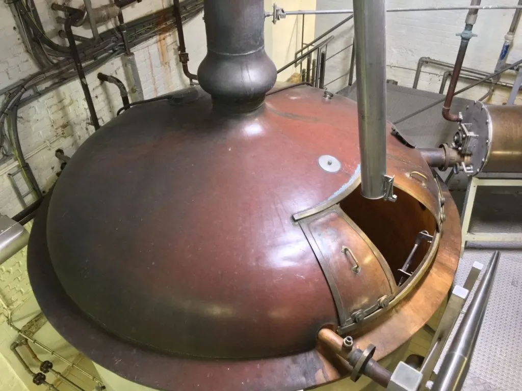 Cuba de cobre antiga com tampa aberta na fábrica da Saint Bernardus