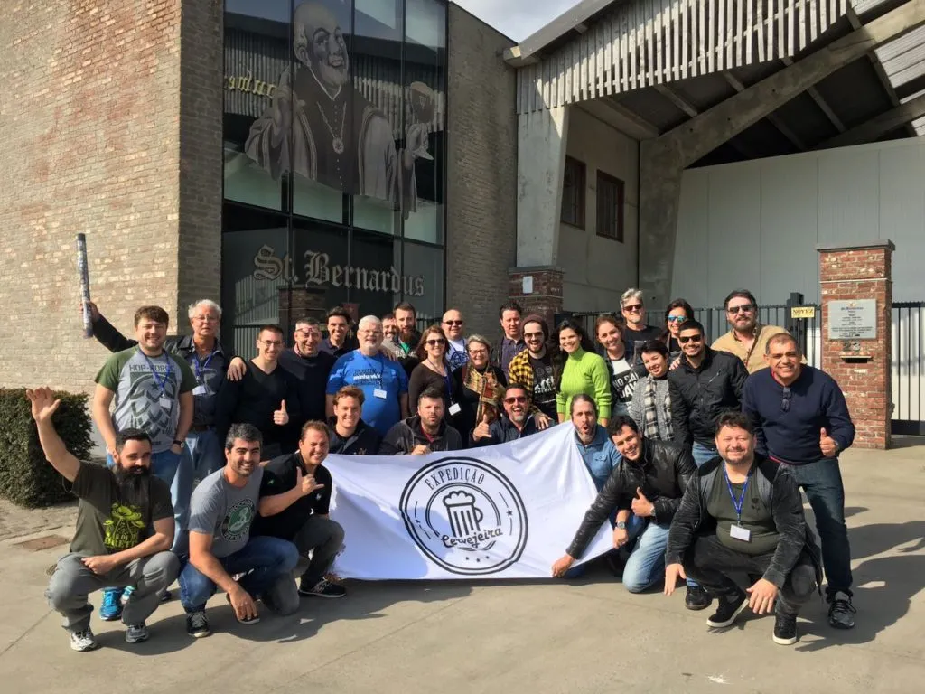 Grupo da Expedição Cervejeira com a bandeira em frente à cervejaria St. Bernardus