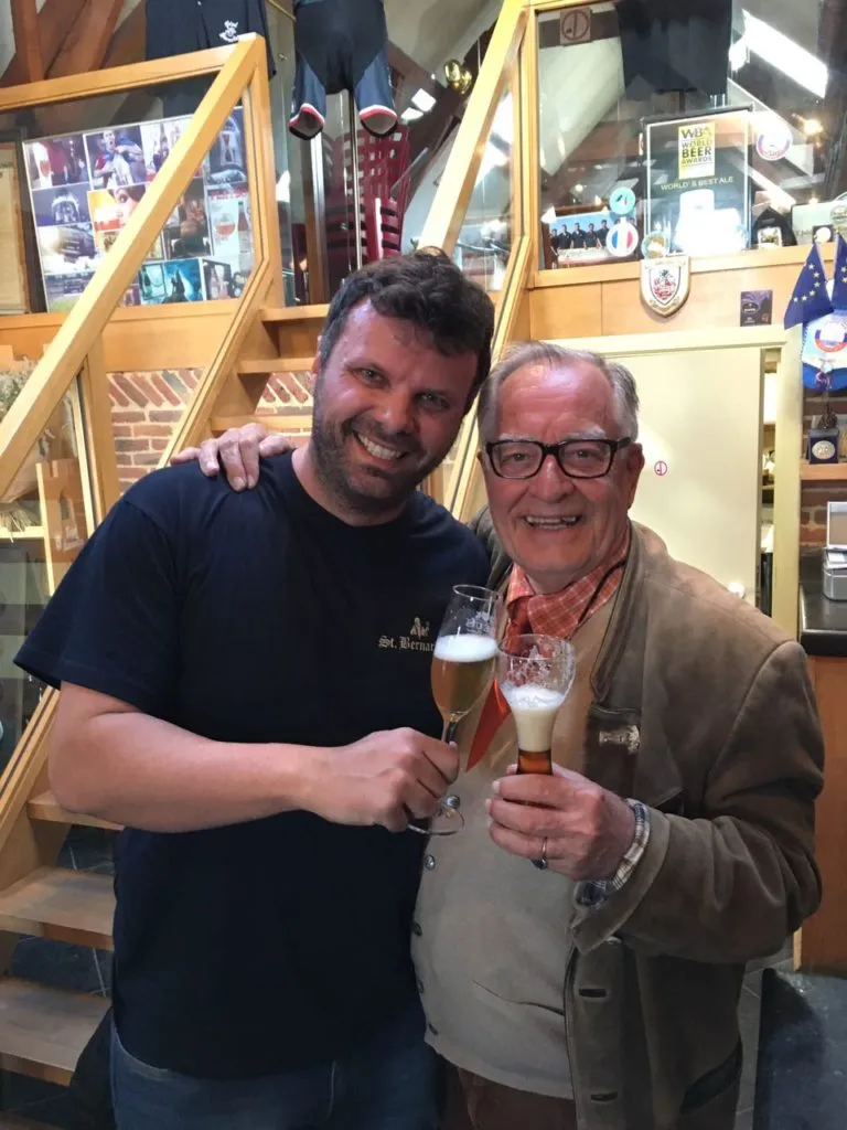 Dois homens brindando com taças de cerveja em ambiente da cervejaria Bosteels